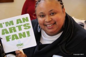 Woman holding an "I'm an Arts Fan" sign