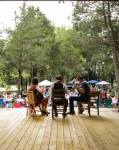 Musicians performing to an audience in an outdoor setting
